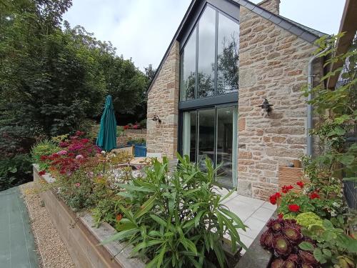 a garden in front of a house with plants at le petit moulin de Kerloroc in Ploudalmézeau
