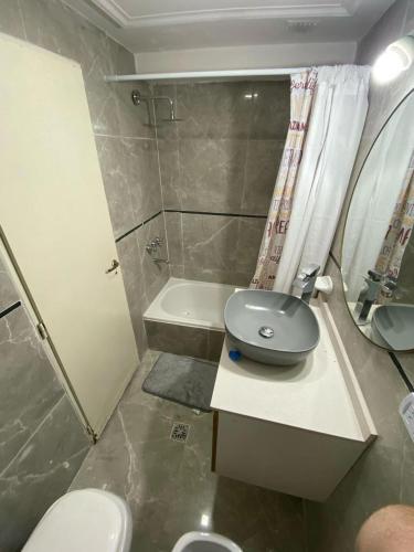 a small bathroom with a toilet and a sink at Lorenzo Suites Hotel in San Miguel de Tucumán