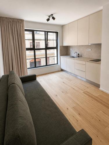 a living room with a couch and a kitchen at Studio 202 in Brno