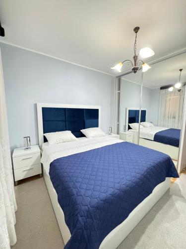 a bedroom with a large bed with a blue comforter at Guest House Darka in Bijela