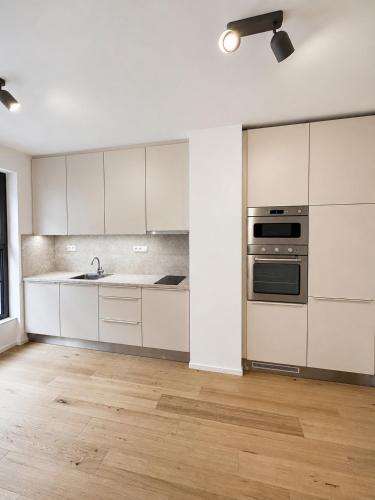 an empty kitchen with white cabinets and a stove at Studio 202 in Brno
