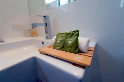 a bathroom with a sink and a shelf with towels at Apartments by Townhouse in Wagga Wagga