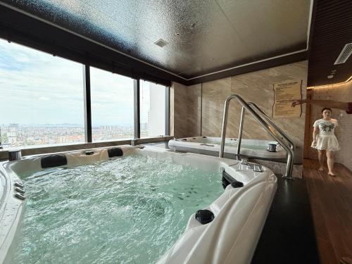 a woman standing in a jacuzzi tub in a building at Mai home in Hai Phong