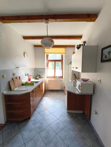 a large kitchen with a sink and a window at Pension V Doubí apartmán se sdílenou koupelnou in Slavče