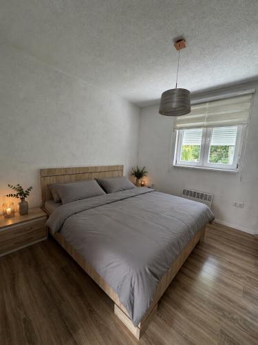 a bedroom with a large bed and a window at Apartment Harmony Sarajevo Vogošća in Vogošća
