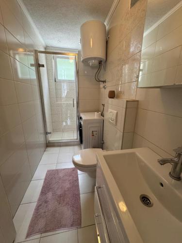 a small bathroom with a sink and a toilet at Apartment Harmony Sarajevo Vogošća in Vogošća