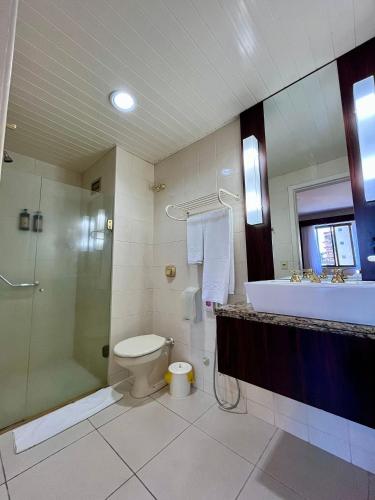 a bathroom with a toilet and a shower and a sink at Studio apartment in downtown Joinville, SC in Joinville