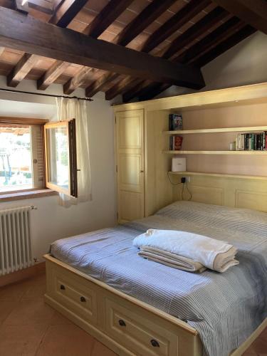 a bedroom with a bed with blue sheets and a window at Il Cantinone A due passi dal mare in San Vincenzo