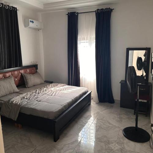 a bedroom with a bed and a large window at House 22 Apartments in Kubwa