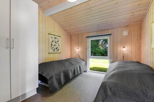 a bedroom with two beds and a window at C11333-Tarm-Laksestien-6 in Tarm