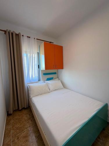 a small bedroom with a bed and a cabinet at Villa DEA in Velipojë