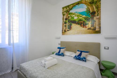 a bedroom with a bed with a painting on the wall at SpeziAMo Rooms in La Spezia
