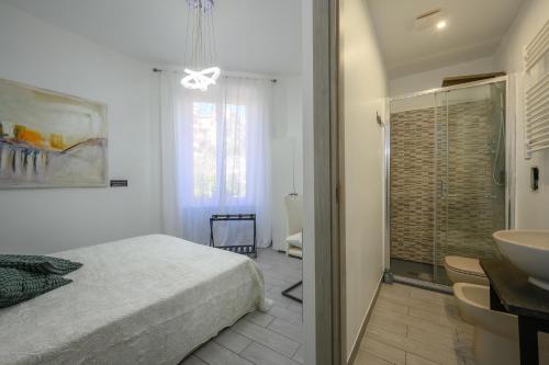 a bedroom with a bed and a bathroom with a sink at SpeziAMo Rooms in La Spezia