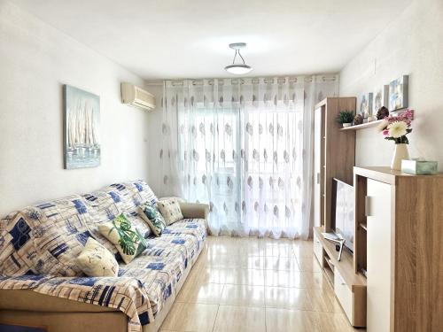 a living room with a couch and a tv at Apartamento Trebol 2 in Oropesa del Mar