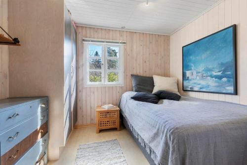 a bedroom with a bed and a dresser and a window at 84300-Ebeltoft-Bogfinkevej-17 in Fuglslev