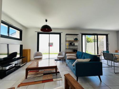 a living room with a blue couch and a table at Casa Avrillé in Avrillé