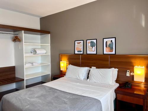 a bedroom with a large bed with a wooden headboard at Studio apartment in downtown Joinville, SC in Joinville