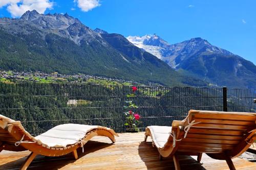 a deck with two chairs and a view of mountains at Mattertal Lodge in Embd