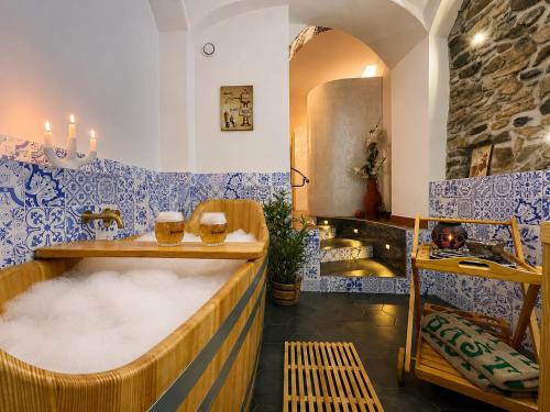 a bathroom with a soak tub with blue and white tiles at Apartmány Bašta & Wellness in Sušice