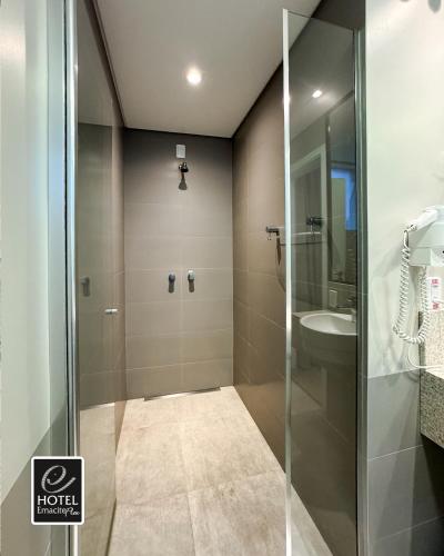 ein Badezimmer mit Glasdusche und Waschbecken in der Unterkunft Hotel Emacite Flex in Mafra