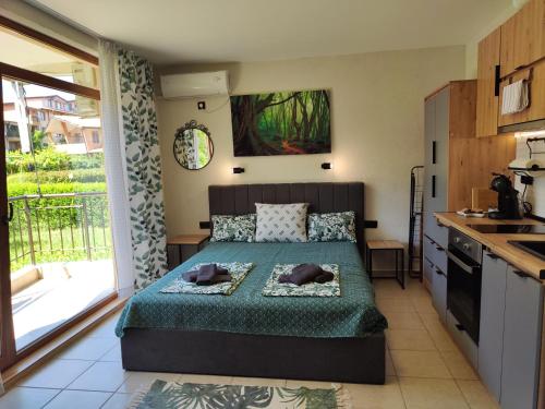 a small bedroom with a bed and a kitchen at Студио Forest, к-с Нестинарка in Tsarevo