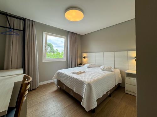 ein Hotelzimmer mit einem Bett und einem Fenster in der Unterkunft Hotel Emacite Flex in Mafra
