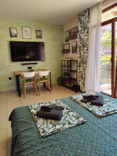 a bedroom with two beds and a table and a television at Студио Forest, к-с Нестинарка in Tsarevo