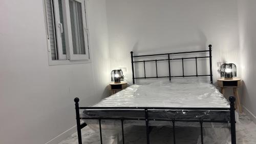 a bed in a white room with two lamps at Casa Mercurio 31 in Torrox