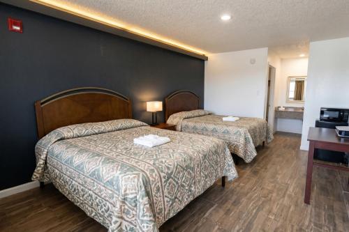a hotel room with two beds and a desk at Garland Inn & Suites near Dallas TX in Garland