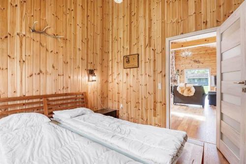 a bedroom with a bed and a wooden wall at L40-Rodby-Glentevej-11 in Rødby