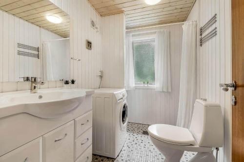 a white bathroom with a sink and a washing machine at C11252-hemmet-Anevej-7 in Hemmet