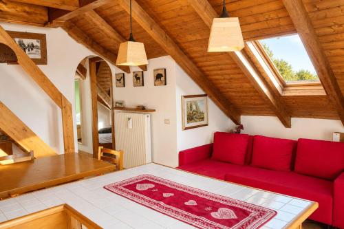 a living room with a red couch and a table at Appartamento Belvedere in Asiago