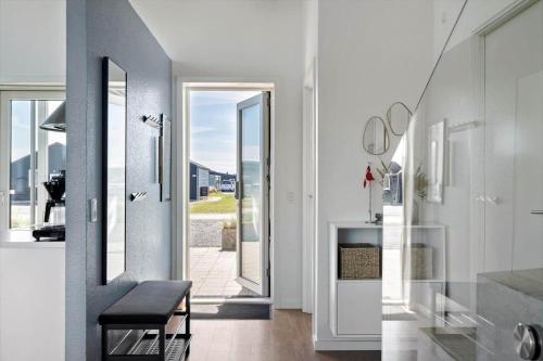 a hallway with white walls and a staircase with a black stool at 1166-Ringkobing-Havstien-388 in Søndervig