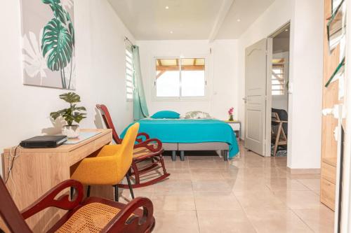 a room with a bed and a table and chairs at Villa Syleone in Sainte-Marie