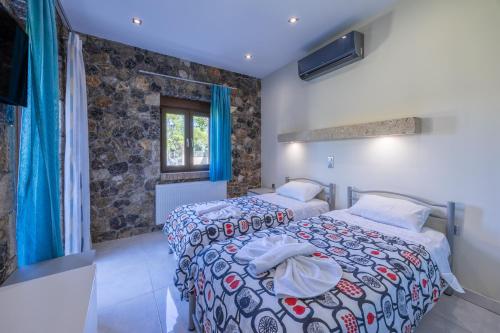 a bedroom with two beds and a window at Villa Afroditi by Bostonia Village in Almiros Beach