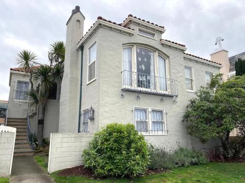 a white house with a balcony and palm trees at Spacious Private Suite ParksBoatingGolf in San Francisco