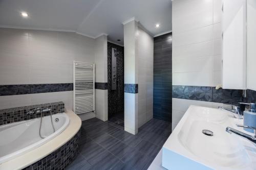 a bathroom with a bath tub and a sink at Villa Afroditi by Bostonia Village in Almiros Beach