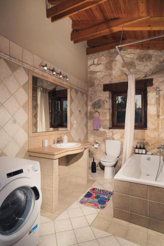 a bathroom with a tub and a sink and a toilet at Kidóni Villas in Gaïtánion