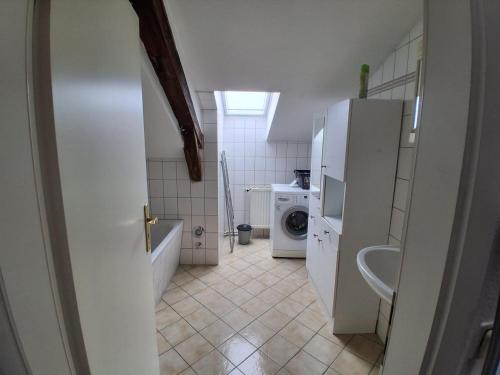 a bathroom with a sink and a washer and dryer at Mittendrin in Stendal