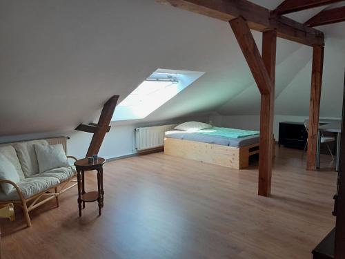 a room with a bed and a couch in a attic at Mittendrin in Stendal