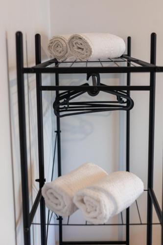a black towel rack with two towels on it at Latitude Guest House in Cantanhede