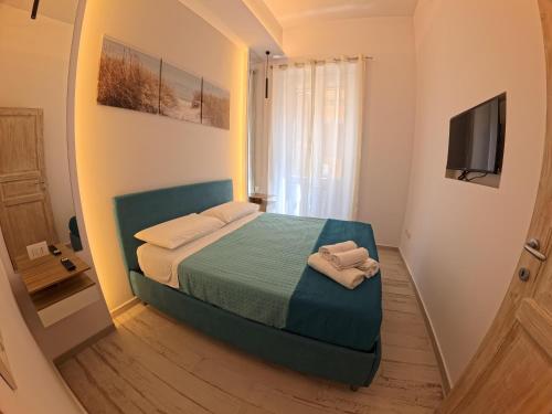 a small bedroom with a bed and a television at La casa di venera in Bacoli