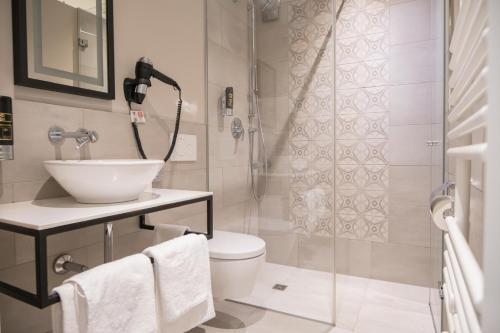 a bathroom with a toilet and a sink and a shower at Hotel Villa Nord Hamburg-Airport in Hamburg