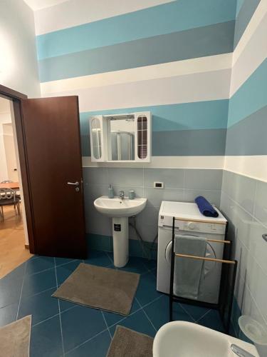a blue and white bathroom with a sink and a mirror at Msholiday home in Cinisi