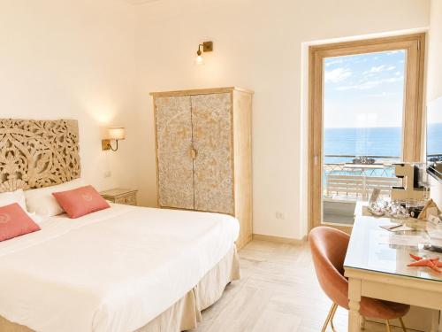 a bedroom with a bed and a desk and a window at Domus Maris Relais Boutique Hotel in Sciacca