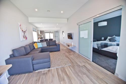 a living room with a couch and a bed at Waterfront Apartments in Devonport