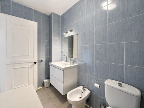 a blue tiled bathroom with a toilet and a sink at Casa Sol de Jandía in Morro del Jable