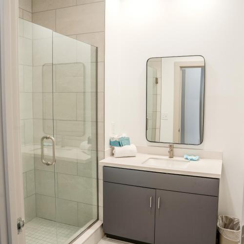 a bathroom with a shower and a sink and a mirror at Driftwood Inn in Mexico Beach