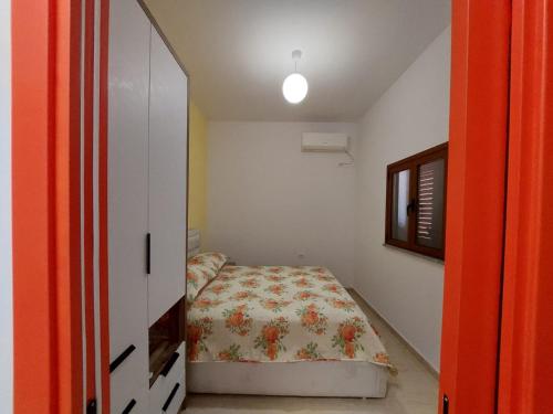 a small bedroom with a bed and a mirror at Villa Shtëpia në Pyll in Draç