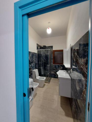 a bathroom with two toilets and a sink at Villa Shtëpia në Pyll in Draç